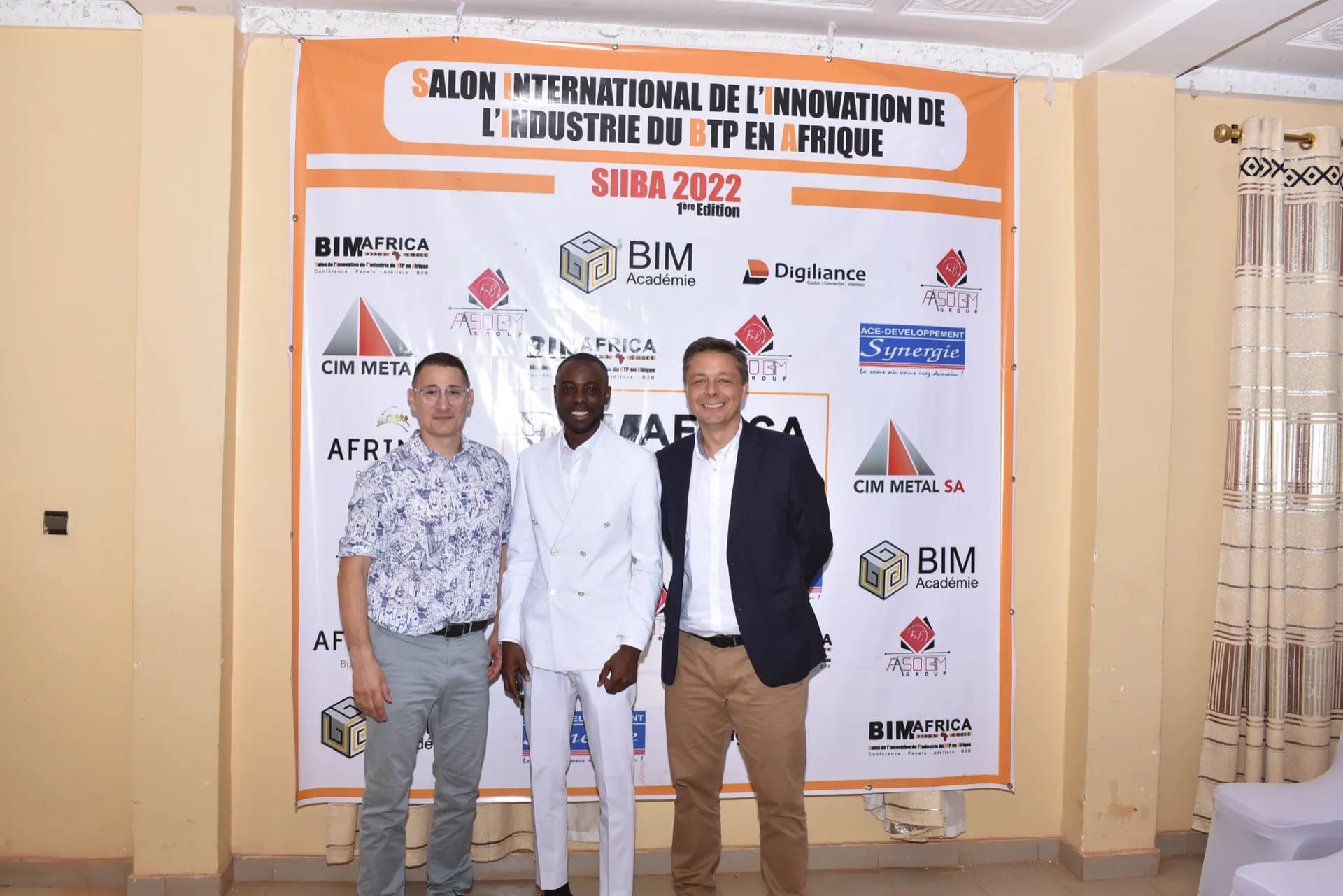 Trio officiel devant la bannière SIIBA 2022 (1ère édition) avec les partenaires internationaux